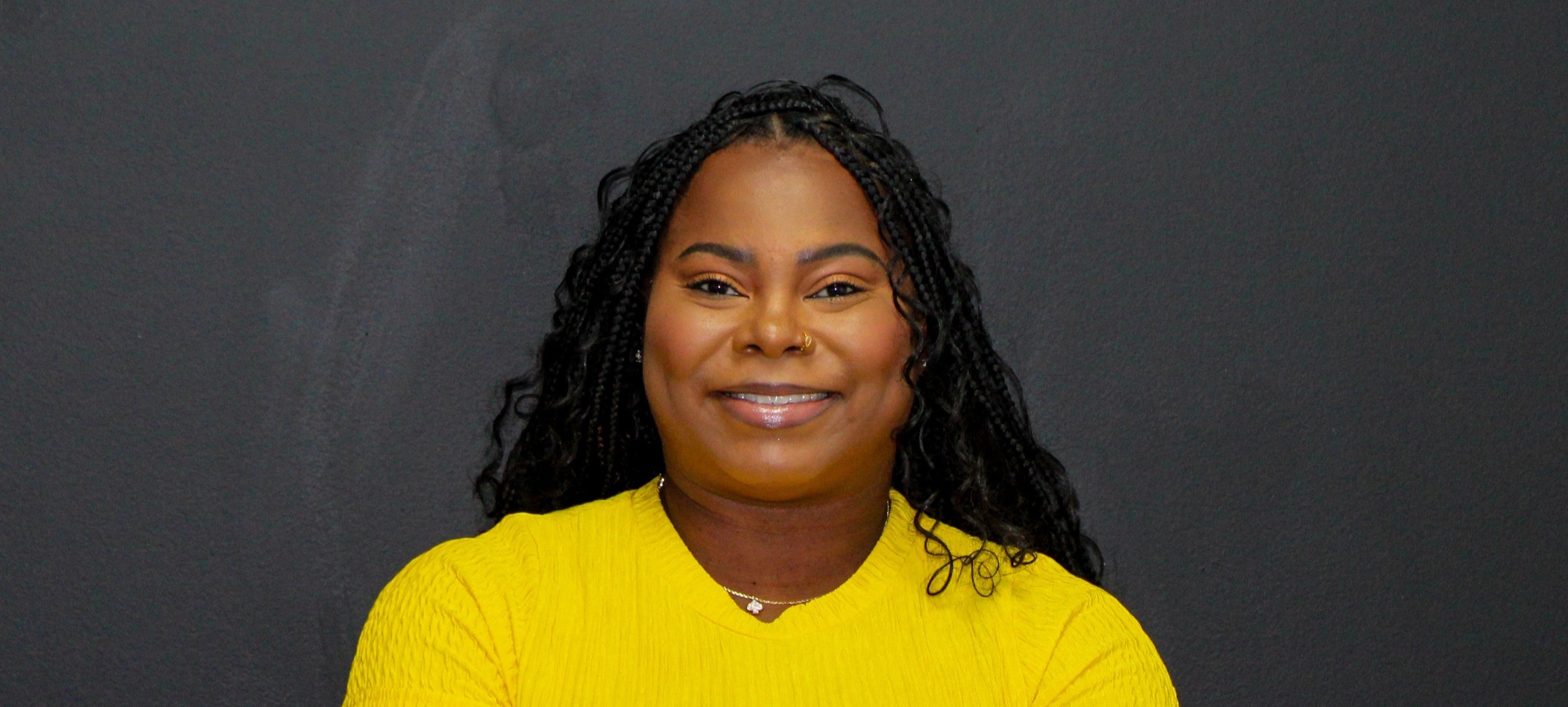 CEO of Beat by Bee company in a yellow shirt standing in front of a black background with 'Beat by Bee' yellow logo.